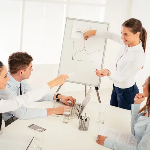Betriebsrat bespricht Mindestlohn 2027 Entwicklung mit Beschäftigten in einem modernen Konferenzraum mit Flipchart und Grafiken