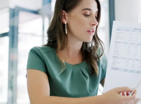 Mitarbeiterin betrachtet nachdenklich ihre Gehaltsabrechnung mit variablen Vergütungsbestandteilen – Symbol für die Notwendigkeit von variabler Vergütung Mitbestimmung durch den Betriebsrat