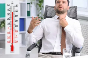 Ein Thermometer im Büro zeigt eine hohe Raumtemperatur und verdeutlicht die Belastung durch Hitze am Arbeitsplatz.