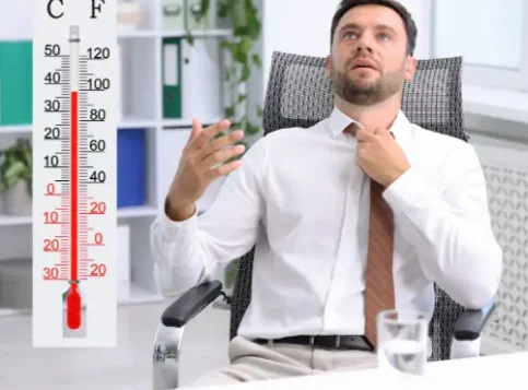 Ein Thermometer im Büro zeigt eine hohe Raumtemperatur und verdeutlicht die Belastung durch Hitze am Arbeitsplatz.