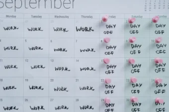 Ein Kalender auf einem modernen Schreibtisch, bei dem die Tage Montag bis Donnerstag farbig markiert sind, passend zum Thema 4-Tage-Woche im Praxistest.