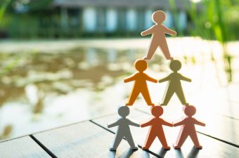 Mitglieder des Betriebsrats analysieren gemeinsam am Besprechungstisch einen Entwurf zur gesundheitsschonenden Schichtplanung.