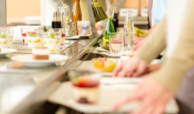 Beschäftigte in der Kantine nutzen einen steuerfreien Essenszuschuss Arbeitgeber für ihr tägliches Mittagessen.
