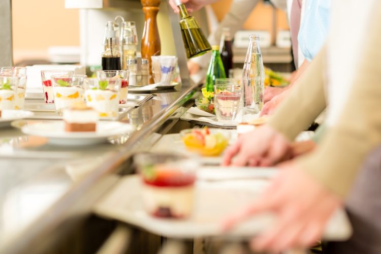 Beschäftigte in der Kantine nutzen einen steuerfreien Essenszuschuss Arbeitgeber für ihr tägliches Mittagessen.